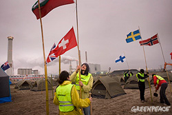 Action on the Maasvlakte: activists plant 18 flags, one for each nationality at the camp